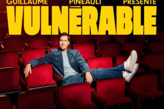 Affiche du nouveau spectacle de Guillaume Pineault, Vulnérable. L'humoriste pose assis dans une salle de salle de spectacle