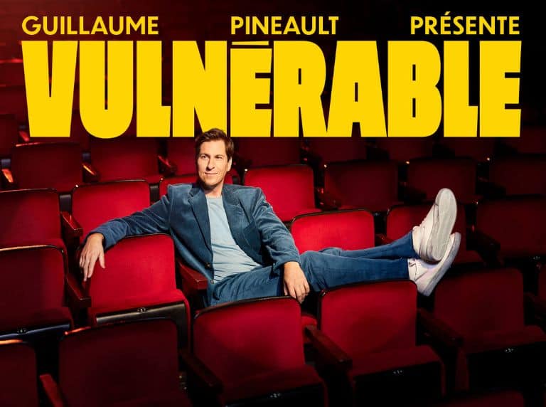 Affiche du nouveau spectacle de Guillaume Pineault, Vulnérable. L'humoriste pose assis dans une salle de salle de spectacle