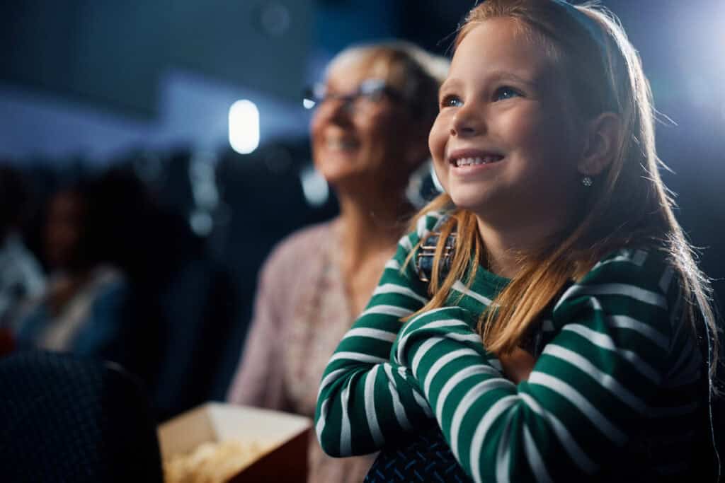 Une jeune fille qui assiste à un spectacle en famille, une belle activité familiale.